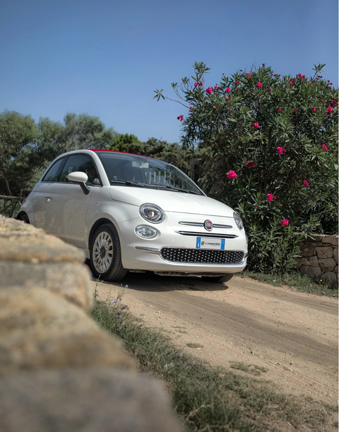 Fiat 500 bianca cabriolet su strada sterrata in Sardegna.