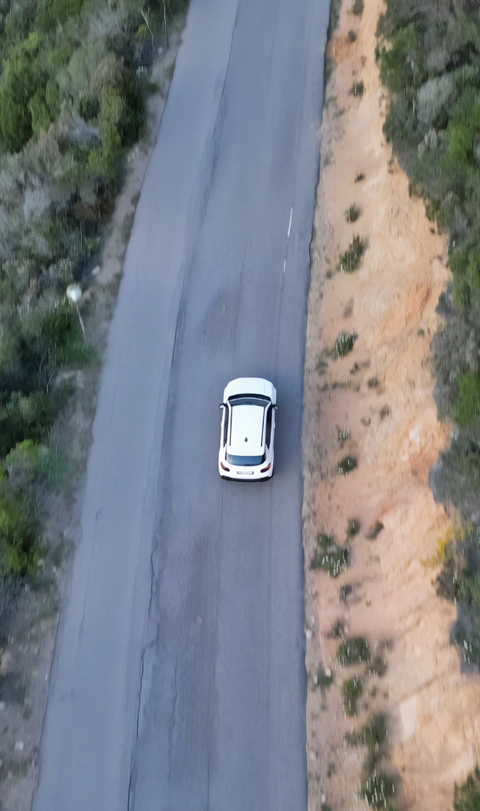 Car rental and road assistance services: white vehicle on a scenic coastal or rural route