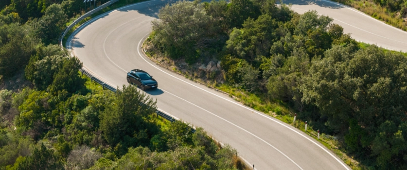 Verkehrsregeln auf Sardinien: Mietwagen auf einer typischen kurvenreichen Straße im Hinterland